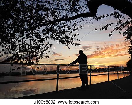 African-American man standing by water at sunset in Washington, D. C., USA. View Large Photo Image Stock Image - African-American man standing by water at sunset in Washington, D. C., USA.. Fotosearch