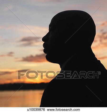 African-American man standing by water at sunset in Washington, D. C., USA. View Large Photo Image Stock Photograph - African-American man standing by water at sunset in Washington, D. C., USA.. Fotosearch