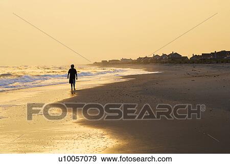Caucasian pre-teen boy walking sihouette on beach at sunset. View Large Photo Image Stock Photo - Caucasian pre-teen boy walking sihouette on beach at sunset.. Fotosearch