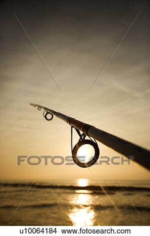 Picture - Fishing pole against ocean at sunset.. Fotosearch