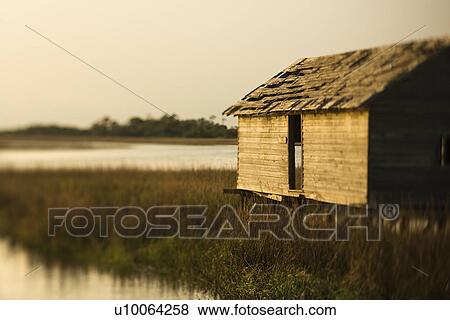 Worn out building in marsh at sunset on Bald Head Island, North Carolina. View Large Photo Image Stock Photo - Worn out building in marsh at sunset on Bald Head Island, North Carolina.. Fotosearch