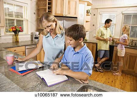 Stock Photo - Caucasian family in kitchen doing homework and chatting.. Fotosearch