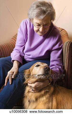 Elderly Caucasian woman in bedroom at retirement community center petting therapy dog. View Large Photo Image Stock Photo - Elderly Caucasian woman in bedroom at retirement community center petting therapy dog.. Fotosearch
