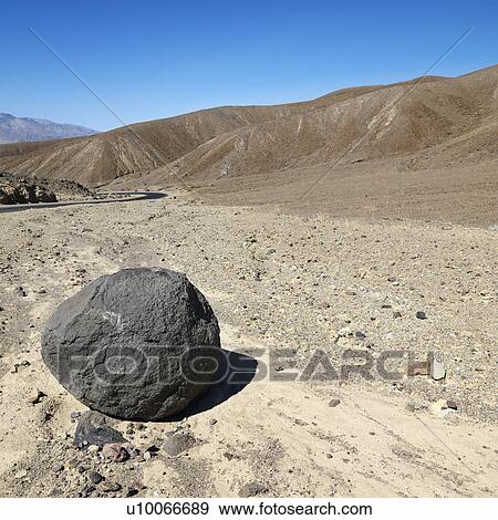 Stock Photo - Boulder in barren landscape in Death Valley National Park.. Fotosearch