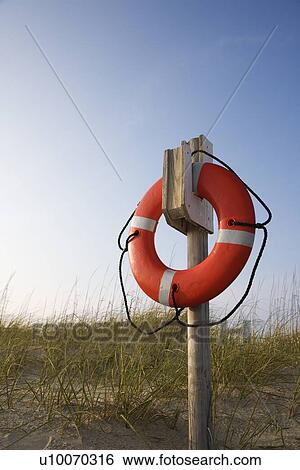 Life preserver hanging on post on beach on Bald Head Island, North Carolina. View Large Photo Image Stock Photograph - Life preserver hanging on post on beach on Bald Head Island, North Carolina.. Fotosearch