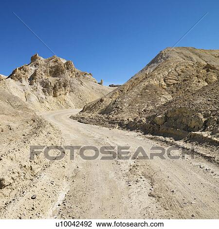 Dirt road through barren landscape in Death Valley National Park. View Large Photo Image Stock Image - Dirt road through barren landscape in Death Valley National Park.. Fotosearch
