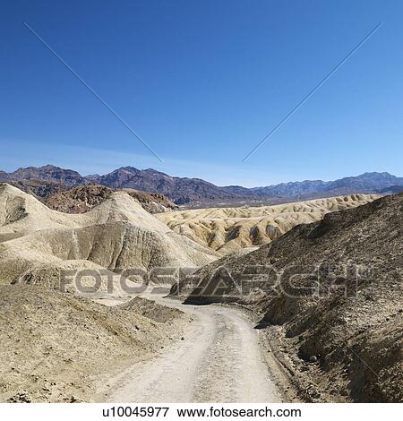 Dirt road through barren landscape in Death Valley National Park. View Large Photo Image Stock Photo - Dirt road through barren landscape in Death Valley National Park.. Fotosearch