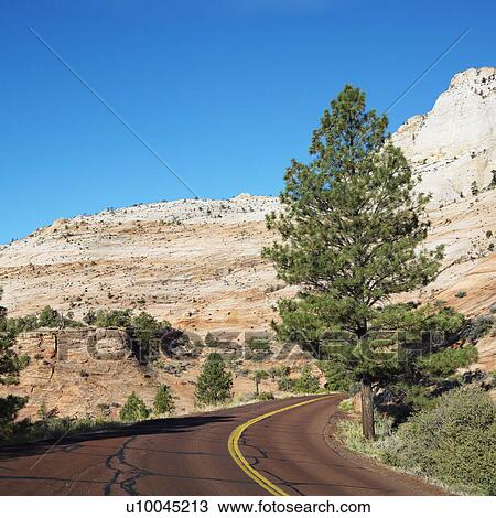 Two lane road winding along desert cliffs in Zion National Park, Utah. View Large Photo Image Stock Image - Two lane road winding along desert cliffs in Zion National Park, Utah. . Fotosearch