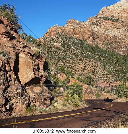 Two lane road winding through rocky desert cliffs in Zion National Park, Utah. View Large Photo Image Stock Image - Two lane road winding through rocky desert cliffs in Zion National Park, Utah.. Fotosearch