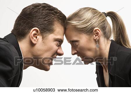 Caucasian mid-adult man and woman with foreheads together staring at each other with hostile expressions. View Large Photo Image Stock Image - Caucasian mid-adult man and woman with foreheads together staring at each other with hostile expressions.. Fotosearch
