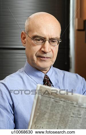Caucasian middle-aged businessman sitting in office reading newspaper. View Large Photo Image Stock Image - Caucasian middle-aged businessman sitting in office reading newspaper.. Fotosearch
