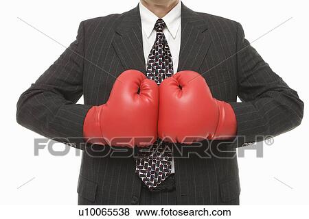 Stock Photo - Caucasian middle-aged businessman wearing boxing gloves . Fotosearch