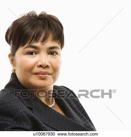 Stock Image - Head and shoulder portrait of Filipino middle-aged businesswoman against white background.. Fotosearch