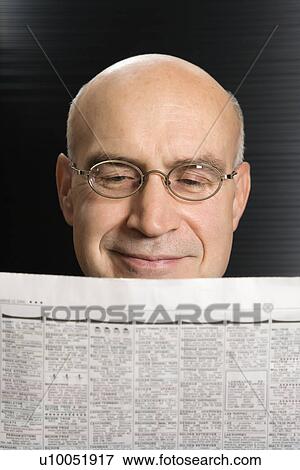 Stock Photo - Head shot of Caucasian middle-aged businessman reading newspaper.. Fotosearch