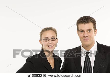 Stock Photograph - Portrait of Caucasian mid-adult businessman and woman smiling and looking at viewer.. Fotosearch