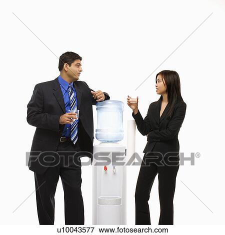 Stock Photo - Vietnamese businesswoman and Indian businessman conversing at water cooler.. Fotosearch