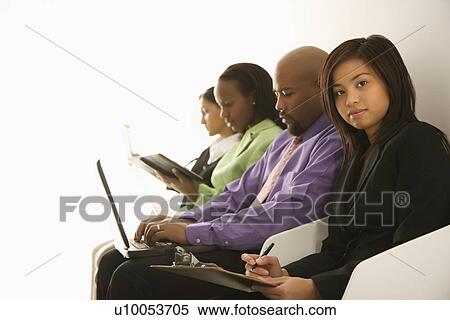 Vietnamese businesswoman sitting with clipboard looking at viewer with others in background. View Large Photo Image Stock Photography - Vietnamese businesswoman sitting with clipboard looking at viewer with others in background.. Fotosearch