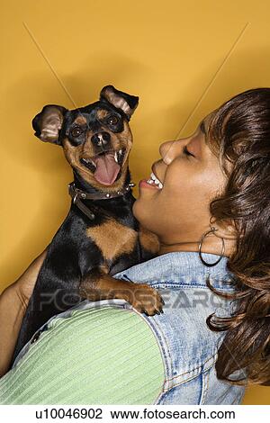 African American young adult female holding Miniature Pinscher dog. View Large Photo Image Stock Image - African American young adult female holding Miniature Pinscher dog.. Fotosearch