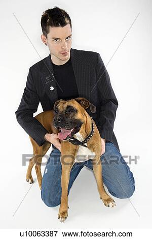 Stock Photo - Young adult Caucasian male with Boxer dog.. Fotosearch