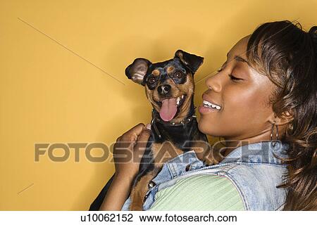 African American young adult female holding Miniature Pinscher dog. View Large Photo Image Stock Image - African American young adult female holding Miniature Pinscher dog.. Fotosearch