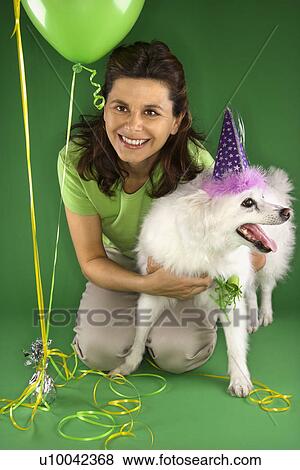 Caucasian prime adult female kneeling with fluffy white dog wearing party hat. View Large Photo Image Stock Photo - Caucasian prime adult female kneeling with fluffy white dog wearing party hat.. Fotosearch