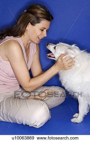 Caucasian prime adult female petting fluffy white dog. View Large Photo Image Stock Photo - Caucasian prime adult female petting fluffy white dog.. Fotosearch