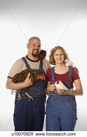 Stock Photo - Caucasian mid-adult woman and man with chickens.. Fotosearch