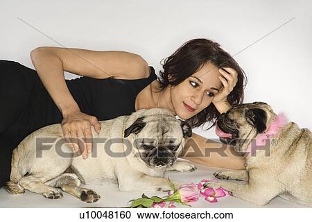 Stock Image - Caucasian prime adult female with two Pug dogs.. Fotosearch