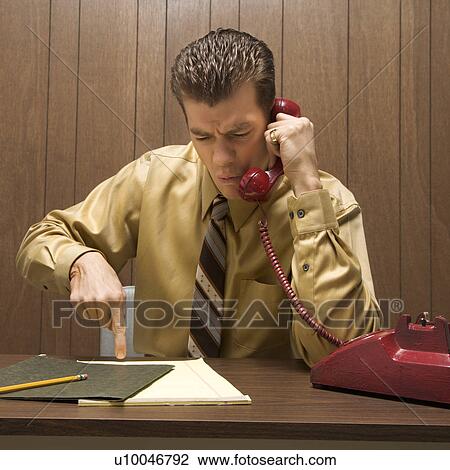 Caucasion mid-adult retro businessman sitting at desk talking on telephone with angry expression. View Large Photo Image Stock Image - Caucasion mid-adult retro businessman sitting at desk talking on telephone with angry expression.. Fotosearch
