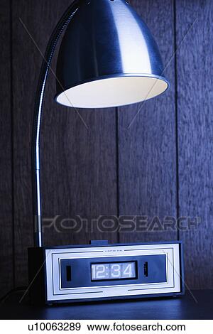 Desk lamp shining down on retro clock against wood paneling. View Large Photo Image Stock Photo - Desk lamp shining down on retro clock against wood paneling.. Fotosearch