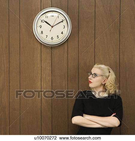 Mid-adult Caucasian female in vintage outfit looking up at clock. View Large Photo Image Stock Image - Mid-adult Caucasian female in vintage outfit looking up at clock.. Fotosearch