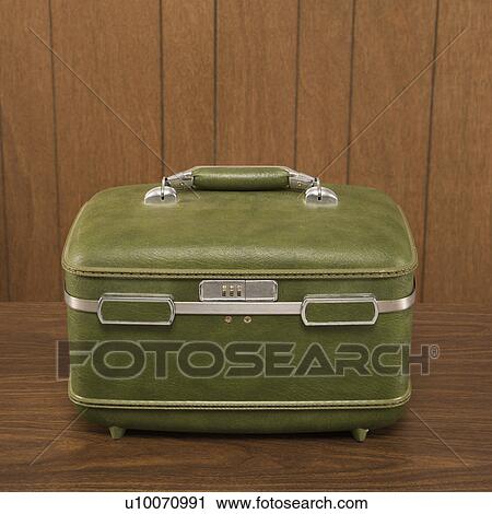 Still life shot of a vintage green luggage piece sitting on a wooden desk. View Large Photo Image Stock Image - Still life shot of a vintage green luggage piece sitting on a wooden desk.. Fotosearch