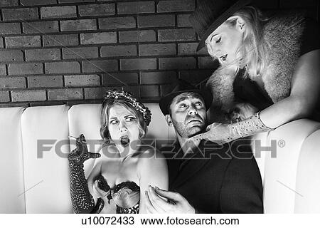 Stock Image - Caucasian prime adult male torn between two Caucasian prime adult females.. Fotosearch