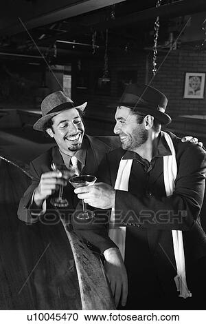 Stock Image - Caucasian prime adult retro males sitting at bar drinking.. Fotosearch