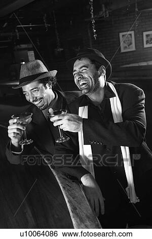 Stock Photograph - Caucasian prime adult retro males sitting at bar drinking.. Fotosearch