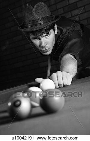Stock Image - Prime adult Caucasian retro male shooting pool.. Fotosearch