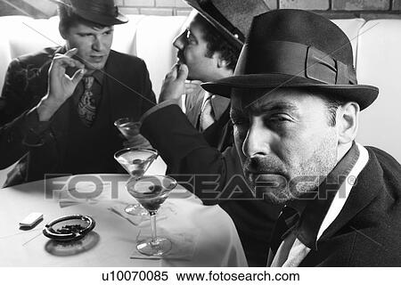 Stock Photography - Three Caucasian prime adult males in retro suits sitting at table.. Fotosearch