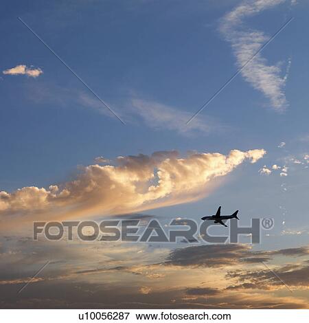Airplane jetting across colored sky. View Large Photo Image Stock Photo - Airplane jetting across colored sky.. Fotosearch