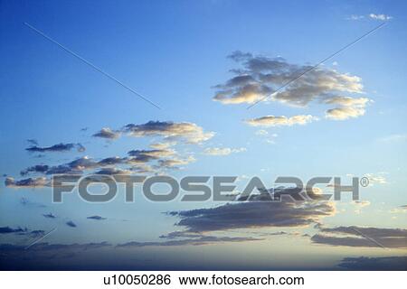Stock Photograph - Blue sky and clouds at dusk over Maui, Hawaii, USA.. Fotosearch