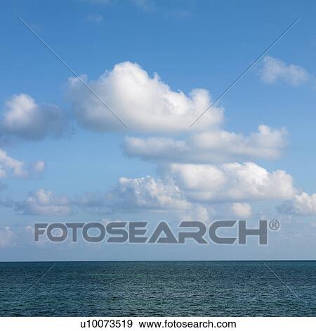 Stock Photo - Calm water and blue sky with white puffy clouds in Florida Keys, Florida, USA.. Fotosearch