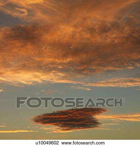 Stock Image - Orange clouds in sky with sunset.. Fotosearch