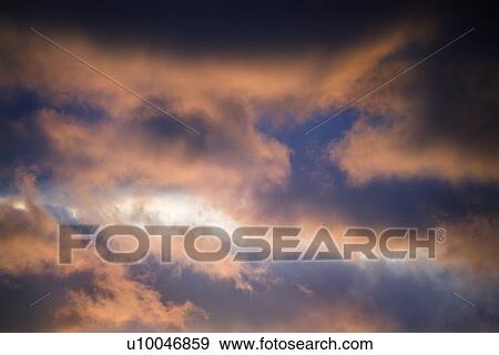 Stock Photo - Red clouds in blue sky at sunset in Maui, Hawaii, USA.. Fotosearch
