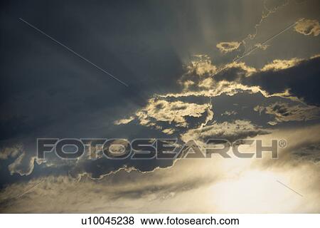 Stock Photo - Sun shining through clouds.. Fotosearch