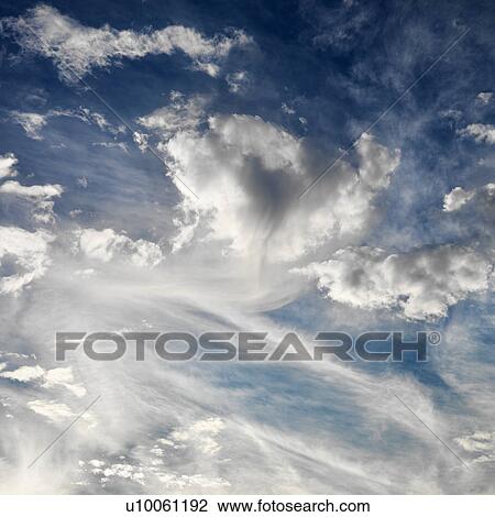 Stock Image - Wispy cloud formations against clear blue sky.. Fotosearch