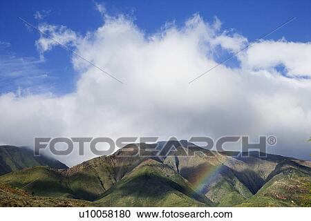Stock Image - Maui mountains with rainbow.. Fotosearch