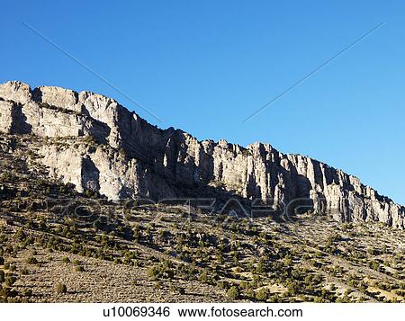 Stock Photograph - Mountain range against clear blue sky.. Fotosearch