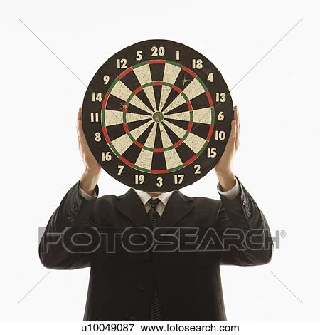 Stock Photo - Caucasian man wearing suit and holding dartboard in front of face.. Fotosearch