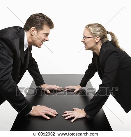 Caucasian mid-adult businessman and woman staring at each other with hostile expressions. View Large Photo Image Stock Image - Caucasian mid-adult businessman and woman staring at each other with hostile expressions.. Fotosearch