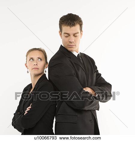 Caucasian mid-adult businessman and woman standing back to back looking at each other. View Large Photo Image Stock Image - Caucasian mid-adult businessman and woman standing back to back looking at each other. . Fotosearch