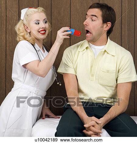 Stock Photo - Caucasian mid-adult female nurse giving mid-adult man giant pill.. Fotosearch